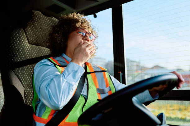 istock Tired female driver yawning while driving a bus. 1485324245