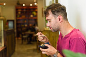 Caucasian man eating tiramisu ice cream in a cafe, copy space