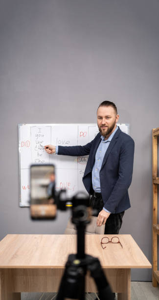 istock Young teacher speaks on video call using smartphone, online english lesson presentation, tutor engaged in webcam virtual class. E-education 1485335039