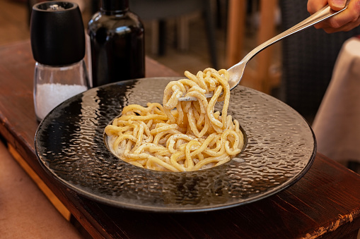 Italian Roman pasta dish cacio e pepe. Traditional for Lazio and Rome. Tonnarelli or spaghetti with black pepper and Pecorino Romano cheese.