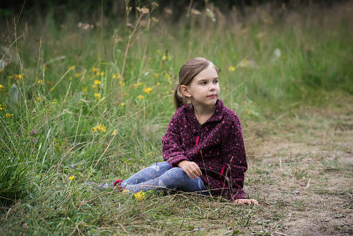 Lovely little girl playing in the summer field