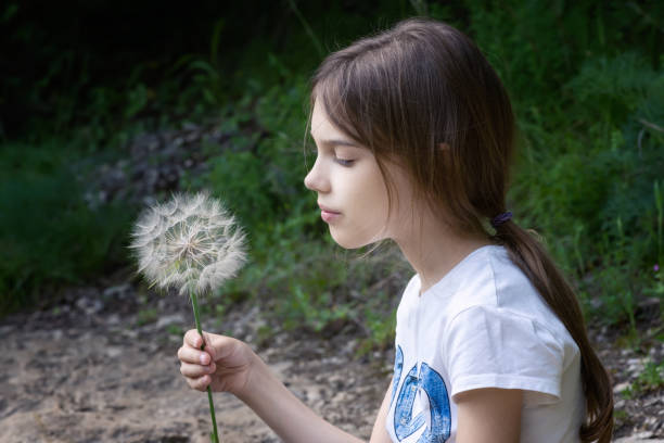 istock Girl and big dandelion in her hand 1485338957
