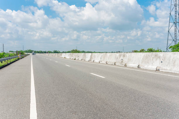 A well maintained stretch of divided highway with a concrete divider or Jersey Barrier in the middle and guard rails on the side. A well maintained stretch of divided highway with a concrete divider or Jersey Barrier in the middle and guard rails on the side. pangasinan stock pictures, royalty-free photos & images