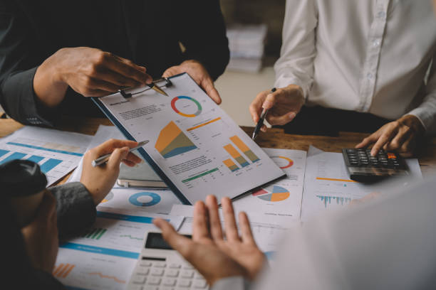 istock Teamwork process, Business team using a calculator to calculate the numbers of statistic business profits growth rate on documents graph data, desk in the office. 1485345281