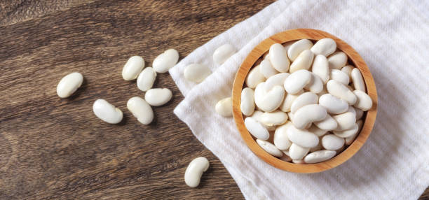 istock Raw white beans in bowl on wooden background 1485346406
