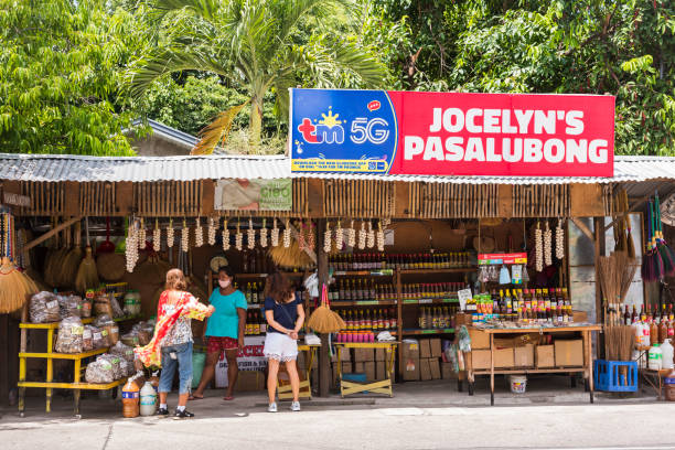 Manaoag, Pangasinan, Philippines - Customers buying food from a Pasalubong store along the highway. Manaoag, Pangasinan, Philippines - June 2022: Customers buying food from a Pasalubong store along the highway. pangasinan stock pictures, royalty-free photos & images
