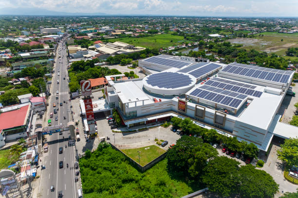 Calasiao, Pangasinan, Philippines - Aerial of Robinsons Place Pangasinan. An array of solar panels are installed on the roof of the mall. Calasiao, Pangasinan, Philippines - June 2022: Aerial of Robinsons Place Pangasinan. An array of solar panels are installed on the roof of the mall. pangasinan stock pictures, royalty-free photos & images