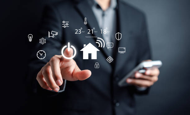 istock Smart home digital remote control on smartphone concept. internet of things in technology control. Businessman holding wooden house with virtual smart home icon function. 1485347004