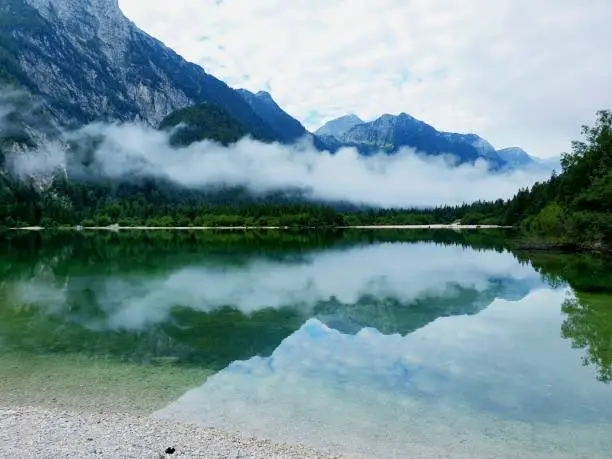 Nebel Wolken und Wasserspiegelung am Predilsee in Italien