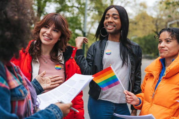 LGBTQIA+ multi ethnic volunteers with rainbow flags in New York stock photo