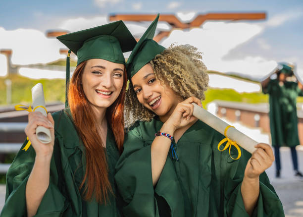 istock two college women recently graduated with diploma - multiracial people students - 1485348894