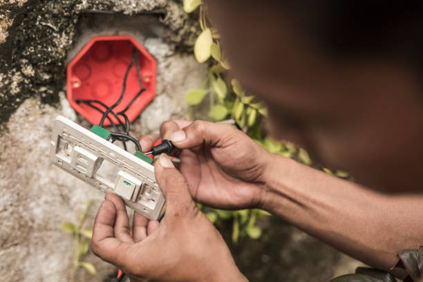 un électricien dépanne une prise combinée extérieure et un interrupteur avec un testeur d’ampèremètre. - switch yard photos et images de collection