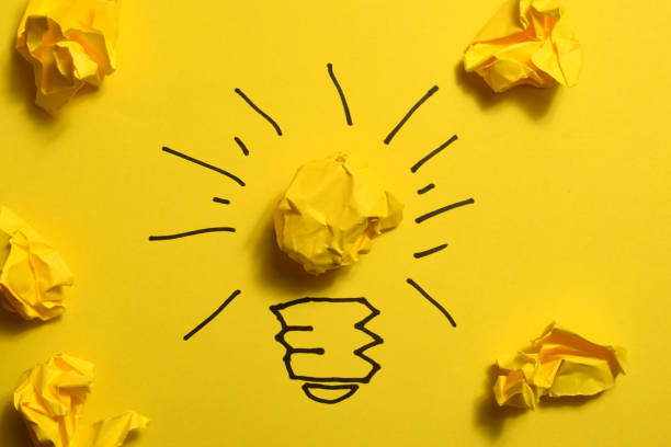 istock Creative thinking ideas and innovation concept. Paper scrap ball yellow colour with light bulb symbol 1485351964