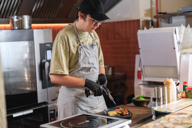 istock Chef in uniform warming up ready dish with fire on restaurant kitchen before serving to client 1485352574
