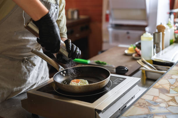 istock Professional kitchen worker cooking egg on a frying pan to make delicious breakfast 1485353843
