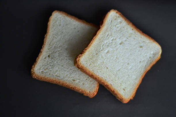 istock Two pieces of bread on a black background 1485353943