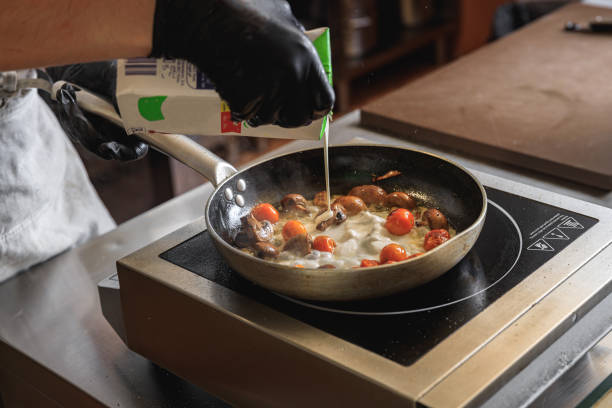 istock The professional chef in uniform adding cream into frying pan with dish in restaurant kitchen 1485355083