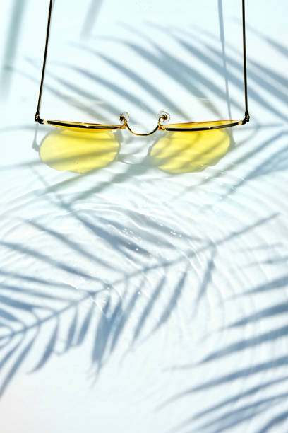 istock Summer flat lay with yellow sunglasses on water background 1485356728