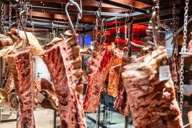 istock Pieces of fresh raw lamb hanging on hooks in the refrigerator 1485356754