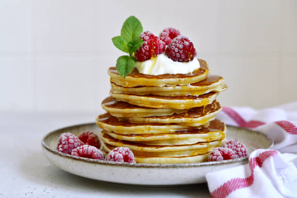 istock Delicious homemade pancakes with whipped cream, maple syrup and raspberry for a breakfast. 1485356801