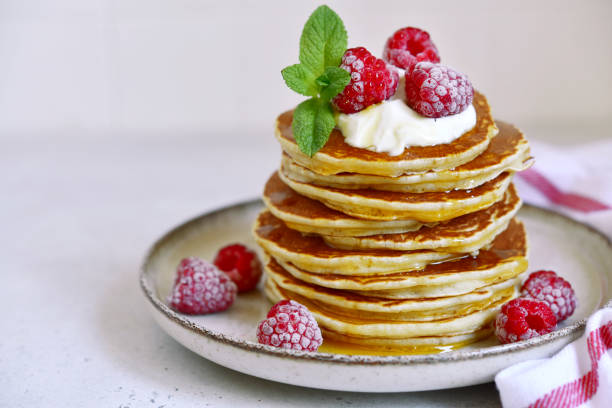 istock Delicious homemade pancakes with whipped cream, maple syrup and raspberry for a breakfast. 1485356995