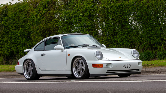 Bicester,Oxon,UK - April 23rd 2023. 1993 white PORSCHE 911 car travelling on an English country road