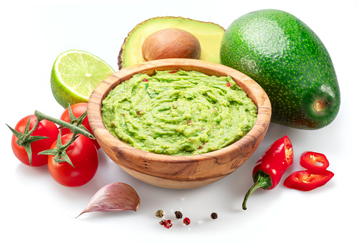 Guacamole bowl and guacamole ingredients isolated on white background.