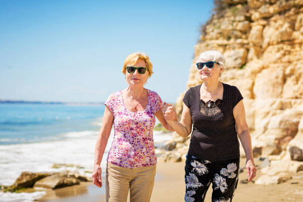 istock Two elderly women are walking along the rocky shore 1485364524