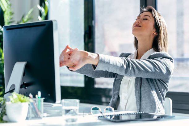 istock Tired businesswoman stretching body for relaxing while working with computer in the office. 1485368949