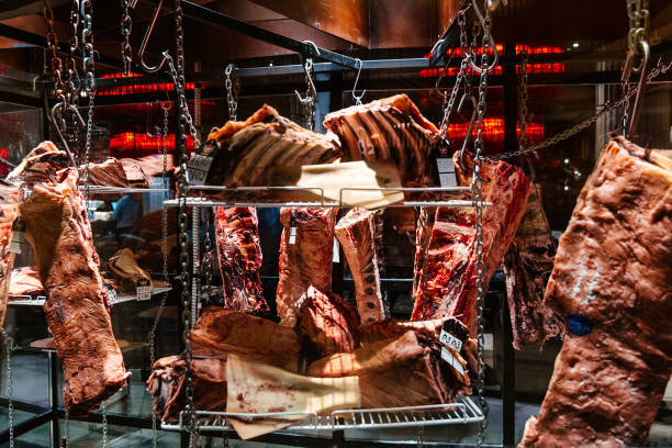 istock Pieces of fresh raw lamb hanging on hooks in the refrigerator 1485370160