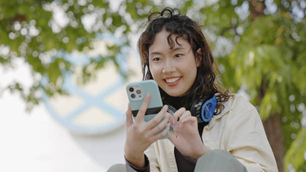 Young Asian women touch screen smartphones to invest in online stocks. stock photo