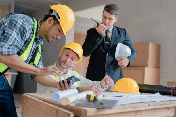 istock multi ethnic engineer brainstorming and measuring for cost estimating on paperworks and floor plan drawings about design architectural and engineering for houses and buildings 1485371828