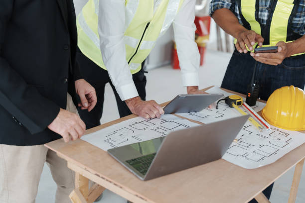 istock multi ethnic engineer brainstorming and measuring for cost estimating on paperworks and floor plan drawings about design architectural and engineering for houses and buildings 1485371954