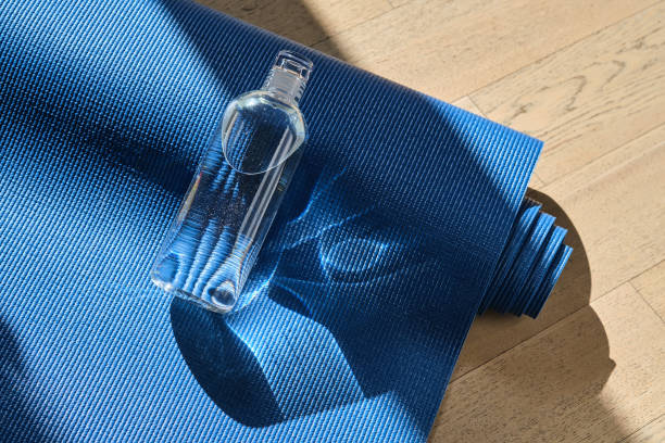 istock Reusable glass water bottle on yoga mat. 1485372100
