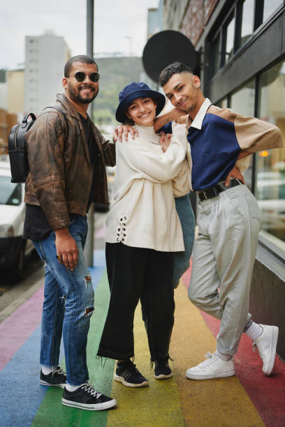 istock Three smiling young friends standing on a sidewalk painted with pride colors 1485373277