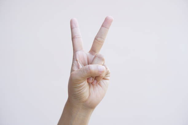 istock Woman holding up two fingers to symbolize fighting 1485376749