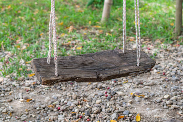 Empty old wooden swing in the park. Space for text. Activity and Relaxation concept.