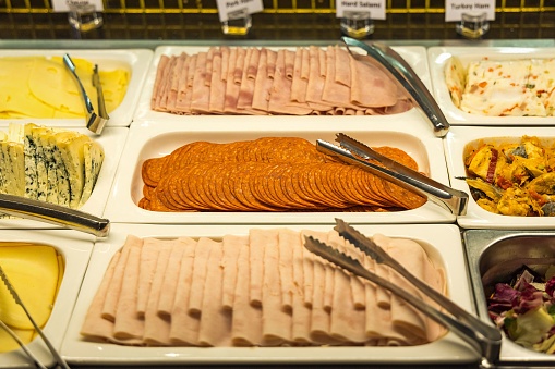Restaurant displaying a selection of assorted sausages on rectangular white plates