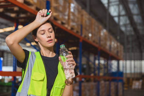 Tired stress woman staff worker sweat from hot weather in summer working in warehouse goods cargo shipping logistics industry. Tired stress woman staff worker sweat from hot weather in summer working in warehouse goods cargo shipping logistics industry. heat stress stock pictures, royalty-free photos & images