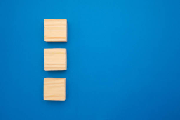 istock Top view of three empty wooden cubes on a blue background. 1485379089