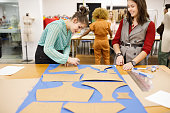 Students tracing out clothing patterns on fabric