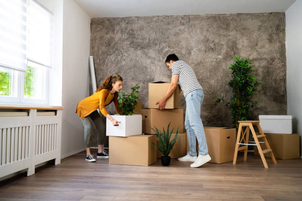 istock Couple carrying cardboard boxes, while moving in, in the new house 1485389096