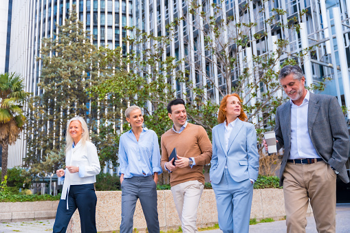 Men and women in business suits walking down street