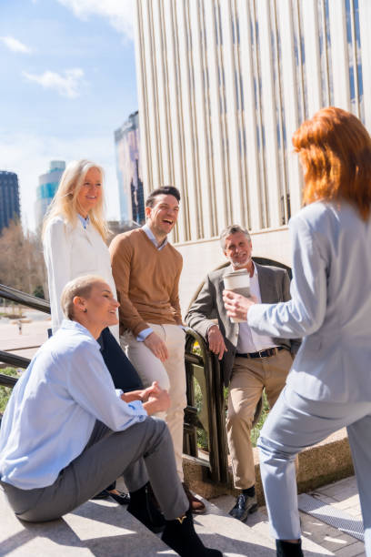 istock Cheerful group of coworkers outdoors in a corporate office area resting and laughing on a sunny morning 1485396708