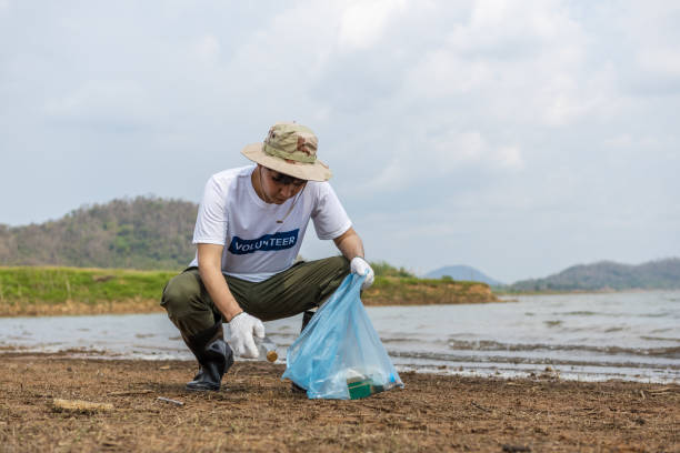 istock Male volunteers collecting garbage, conducting environmental cooperation, saving world reducing global warming, Volunteers clean plastic bag waste in natural attractions. 1485403383
