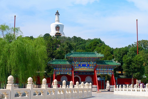 A scenic view of the historic Baita Pailou Bridge in the beautiful Beihai Park in Beijing, China