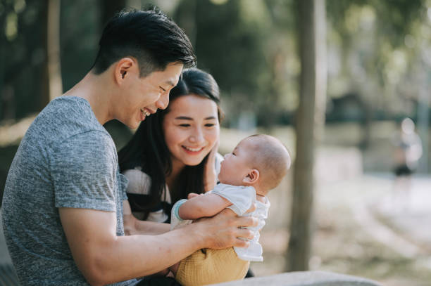 アジアの中国の両親は、週末の朝に公共の公園で男の子と絆を結ぶ - love growth time of day cheerful ストックフォトと画像