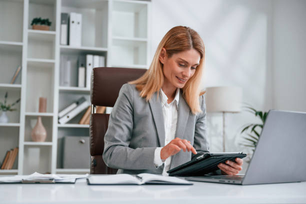 istock Using tablet. Woman in business formal clothes is working in office 1485421287