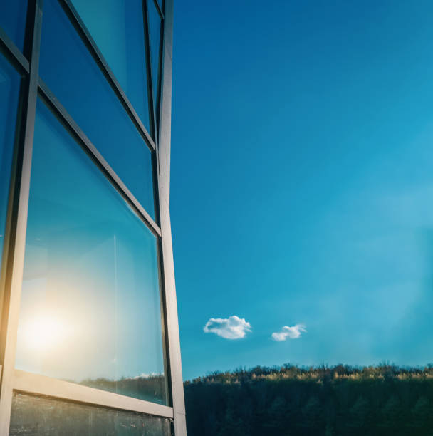 Glass windows of a modern building. Sunlight is reflected in glass