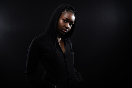 Cool and Beautiful Black Female Model Looking Into Camera on Black Background. Braided hair.